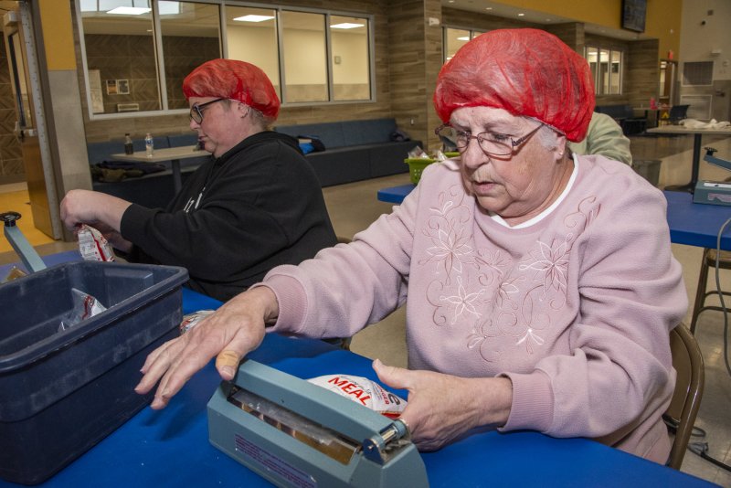 Iva Kline, right, seals a bag, while Tina Collins makes sure the seal is complete.